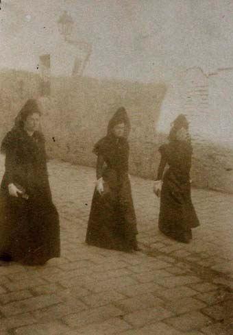 (Tres mujeres con mantilla paseando por una calle)