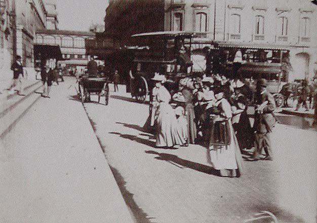 (Tranvías y transeuntes por la calle de una ciudad)