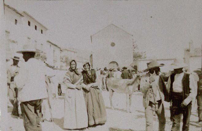 (Grupo de gente en la plaza de un pueblo)