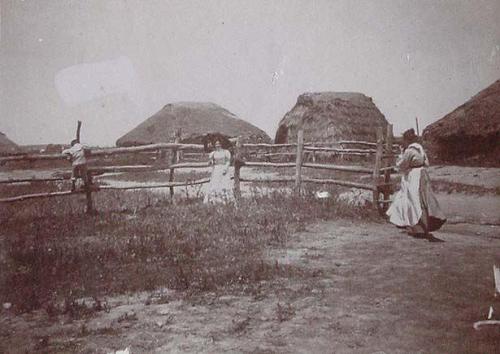 (Dos mujeres junto a unas casas en Puebla ---)