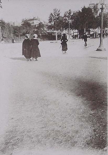 (Mujeres de espaldas paseando por una calle muy ancha)