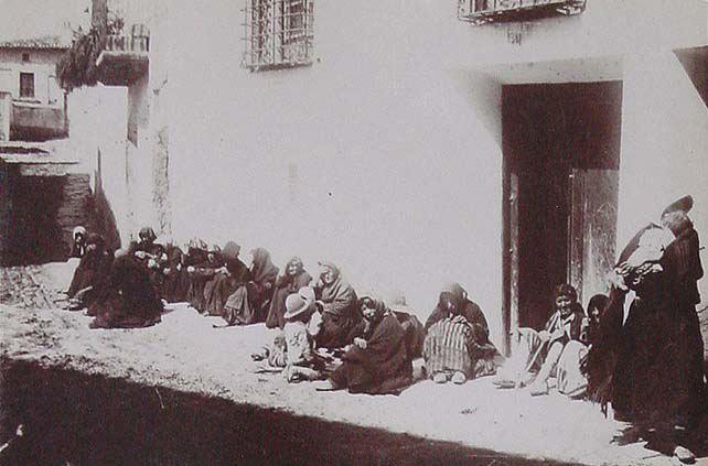 (Mujeres sentadas alrededor de una casa en la Puebla de Don Fadrique)