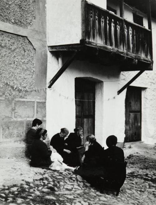 Grupo de mujeres sentadas en la calle de un pueblo