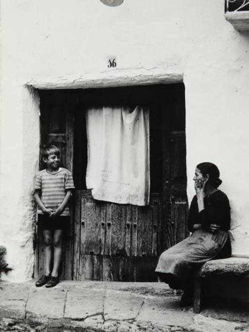 Niño y mujer a la puerta de una casa