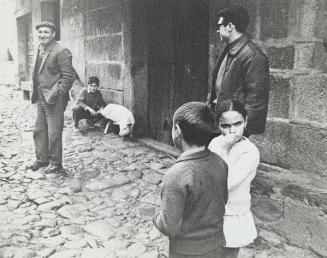 Grupo de personas y cerdo en la calle de un pueblo