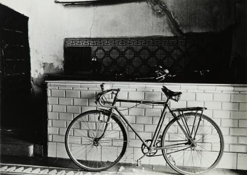 Bicicleta contra un muro de azulejos blancos