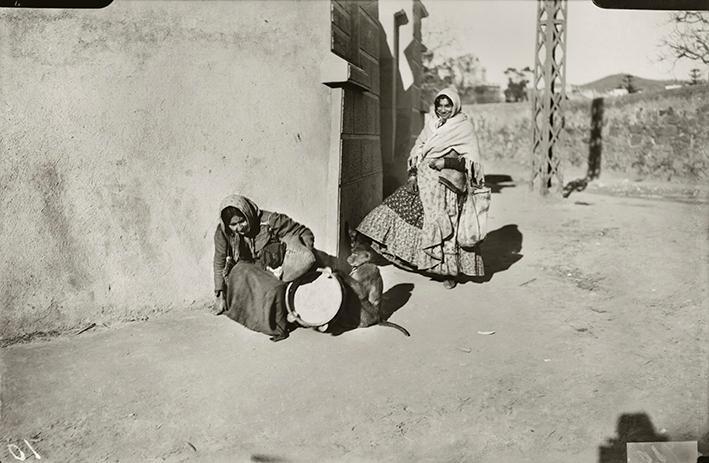 Gitanas ambulantes ofreciendo atracción musical callejera con un mono amaestrado. Barrio de Somorrostro