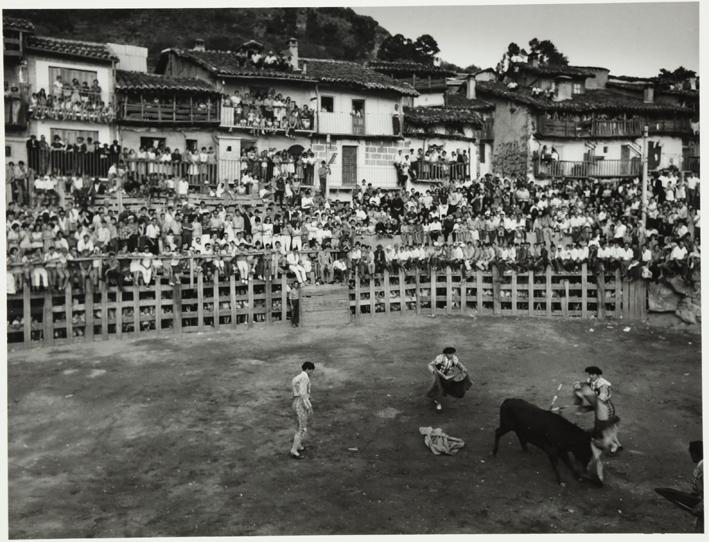 Corrida de toros en una plaza rodeada de casas