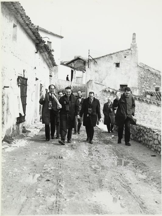 Grupo de fotógrafos camina por la calle de un pueblo