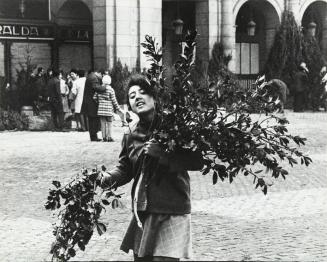 Joven vendedora con ramas de acebo en la Plaza Mayor de Madrid