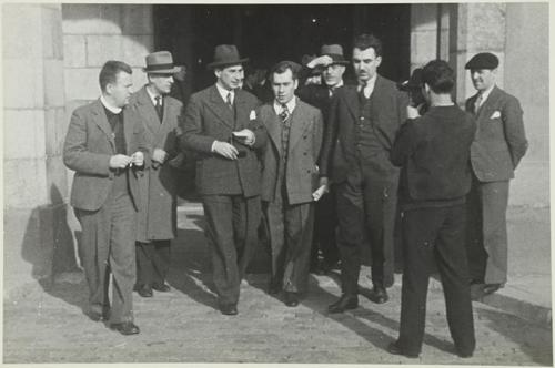 (Grupo de hombres saliendo de un edificio)