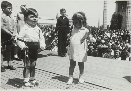 (Niños sobre un escenario en una plaza)