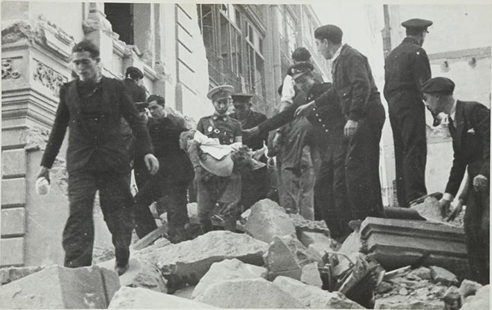 (Gente sacando cuerpos de un edificiio derruido tras un bombardeo)