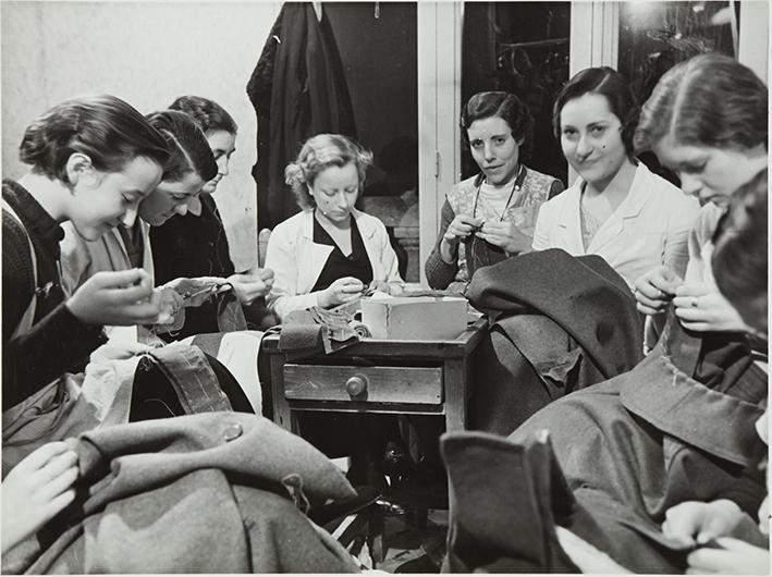 Barcelona. Confección de vestuario de guerra. Mujeres preparando e hilvanando la ropa para la confección de tabardos i capotes